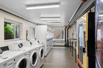 A row of washing machines are lined up in a laundromat.